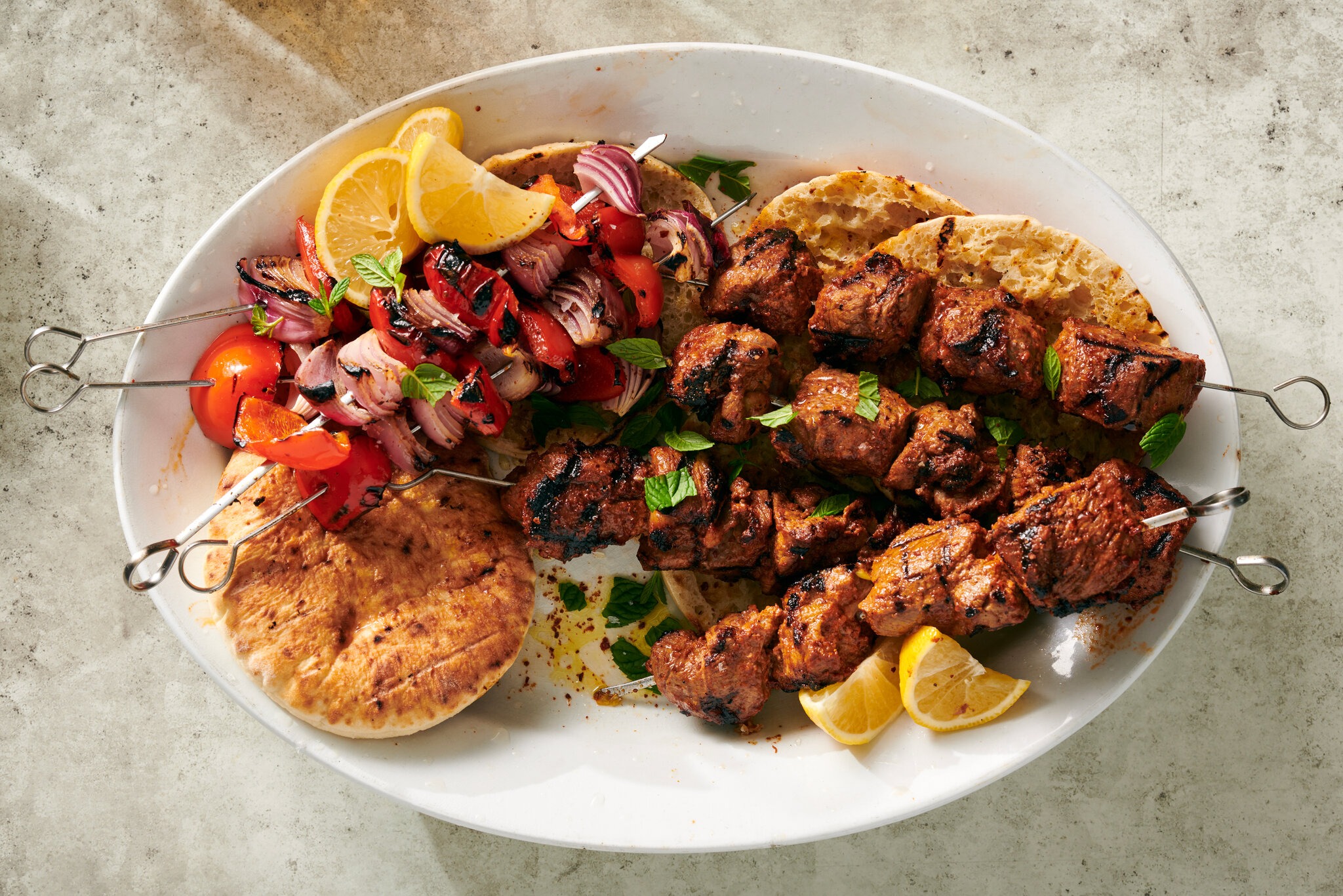 A platter of assorted kebabs with rice and salad 